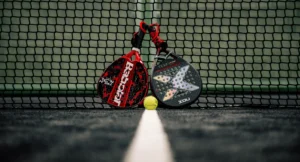 Δύο ρακέτες padel και μία μπάλα μπροστά από το φιλέ, σε κλειστό γήπεδο padel στην Κύπρο